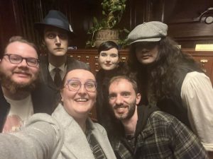 A selfie including some of the cast of the show. They are dressed in period costumes, and their makeup is very pale.