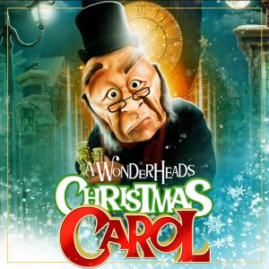 The Wonderheads Christmas carol poster. A green background with a large clock. Ebenezer Scrooge is in the centre represented with a large mask, his face somewhat turned down on one side.