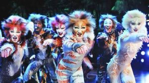 A still from the musical cats. Performers wear stylized dance outfits with cat ears and tails, and are wearing cat makeup. 